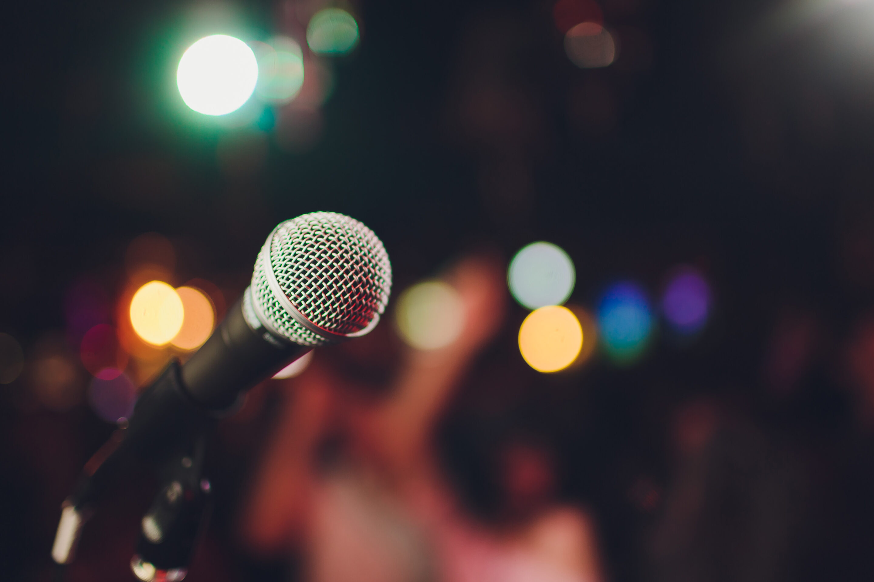 Photo of a microphone with a blurry background of a venue